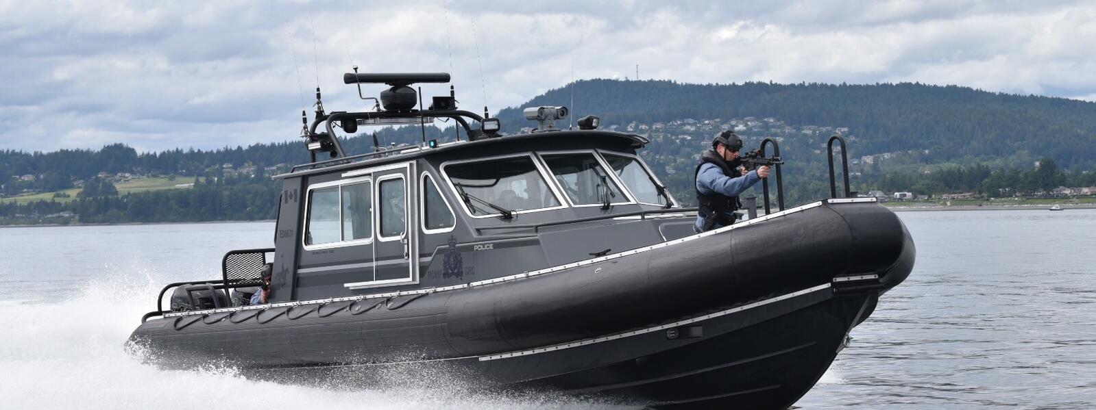 Police force boat with tactical officer and mounted surveillance camera.